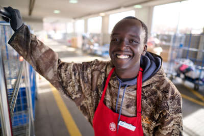 thrift store worker smiles as he helps unload donations from cars